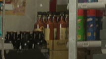 엉클 잭스 리커 계산대 뒤에 있는 Ragga Rum 병이 담긴 개봉된 박스.
