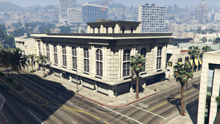 Grand Theft Auto 온라인의 록퍼드 힐즈 발렛 파킹 차고 전경, 판자로 막힌 상점이 길가에 위치.()