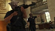 습격 업데이트 공식 스크린샷, 퍼시픽 스탠다드 작업 습격 중 경찰 복장을 착용한 두 명의 GTA 온라인 플레이어.